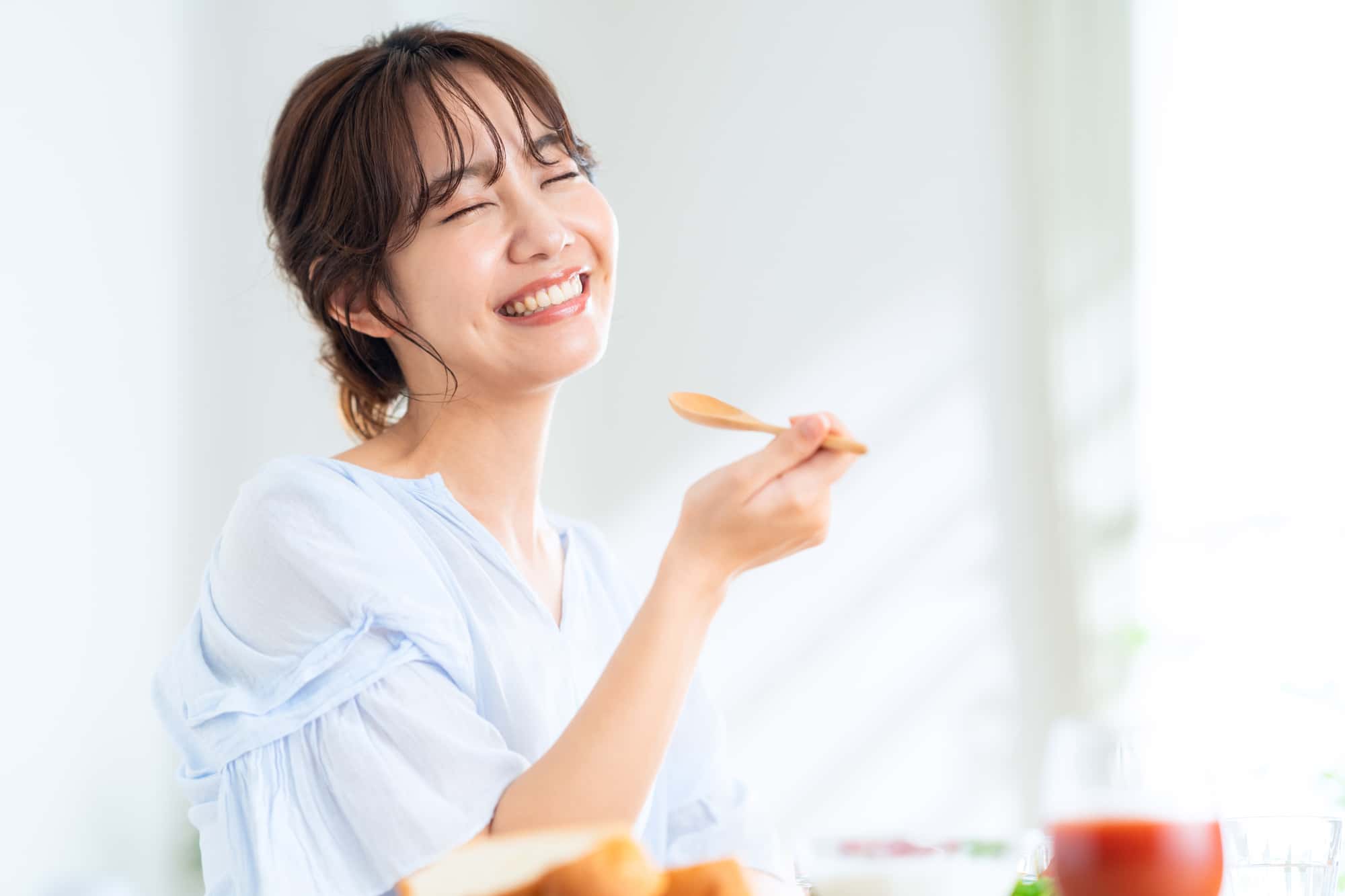 親知らずを抜歯して快適に食事をする女性