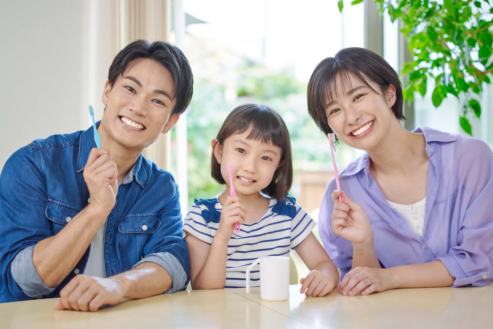 虫歯予防を続けるために一緒に歯みがきをする親子