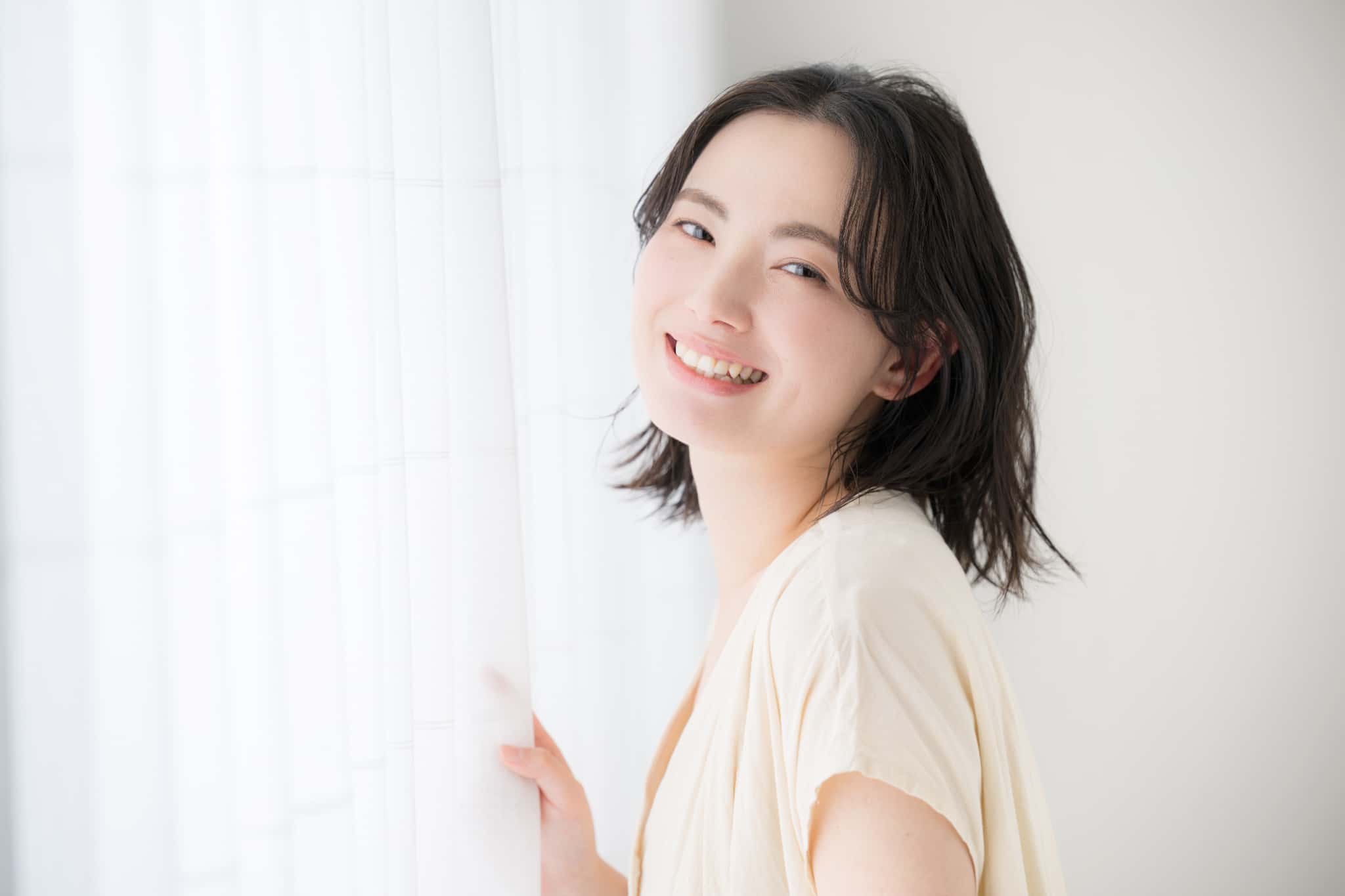 セラミック治療をした白い歯で笑う女性