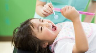 虫歯を予防するため歯科医院で定期検診を受診する子ども