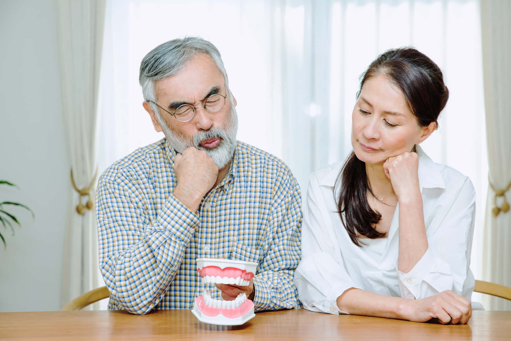 抜歯後のインプラント治療は可能か考える男女