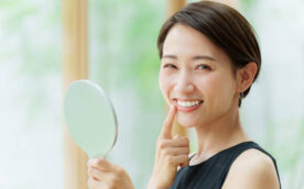 attractive asian woman wearing black dress looking mirror