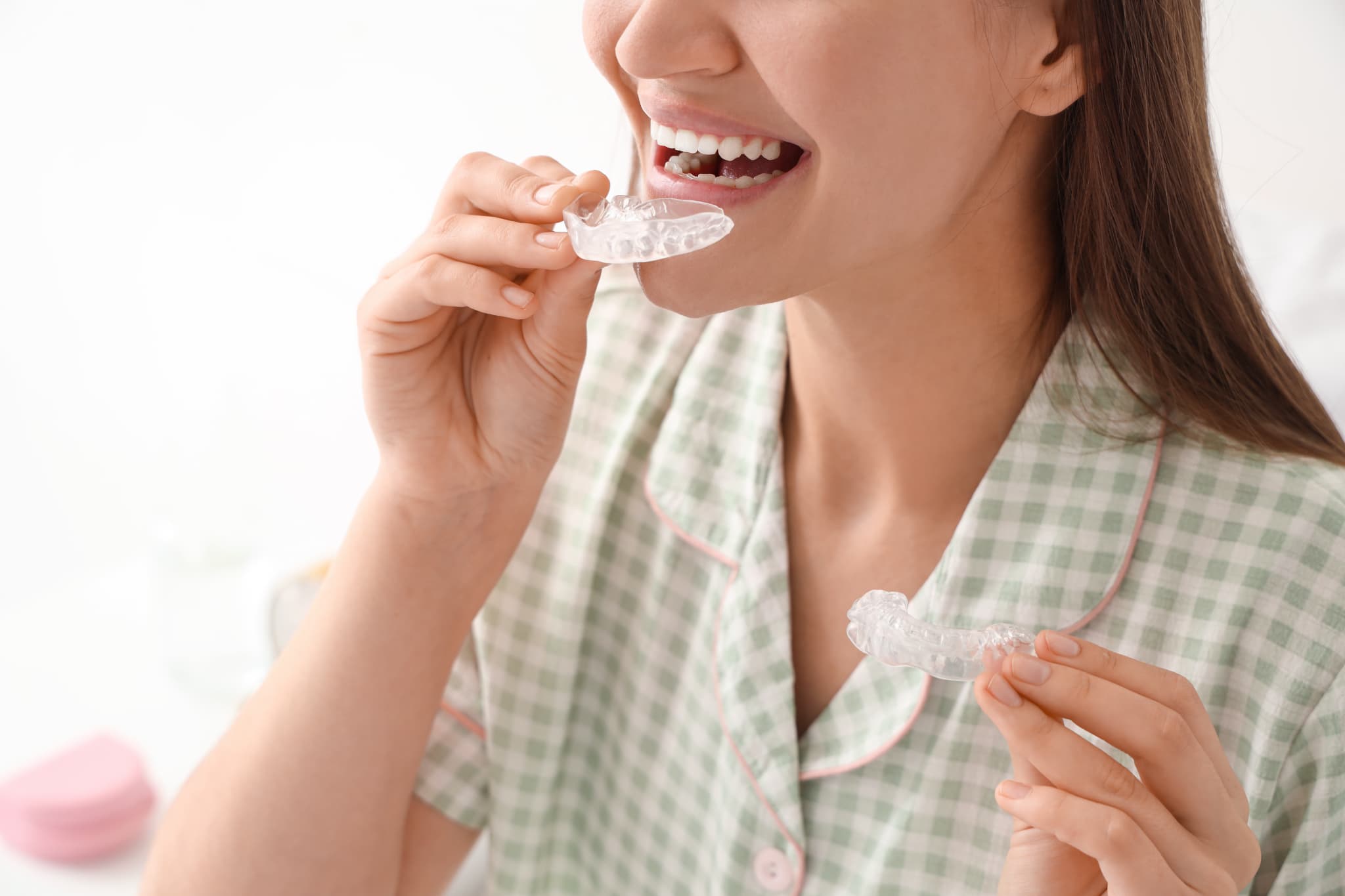 顎関節症の治療のため就寝前にマウスピースを装着する女性
