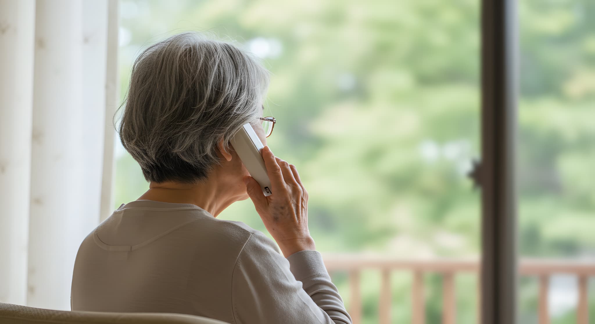 歯科医院へ問い合わせを行う高齢女性