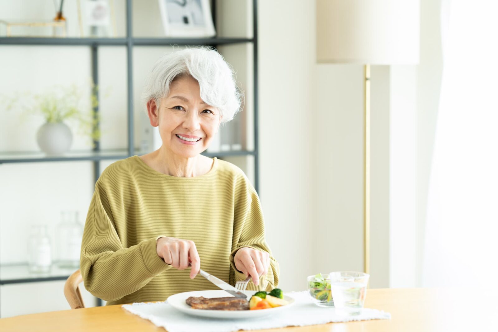 インプラント治療を受けた高齢の方がしっかり噛む必要のあるステーキを食べられるようになったイメージ