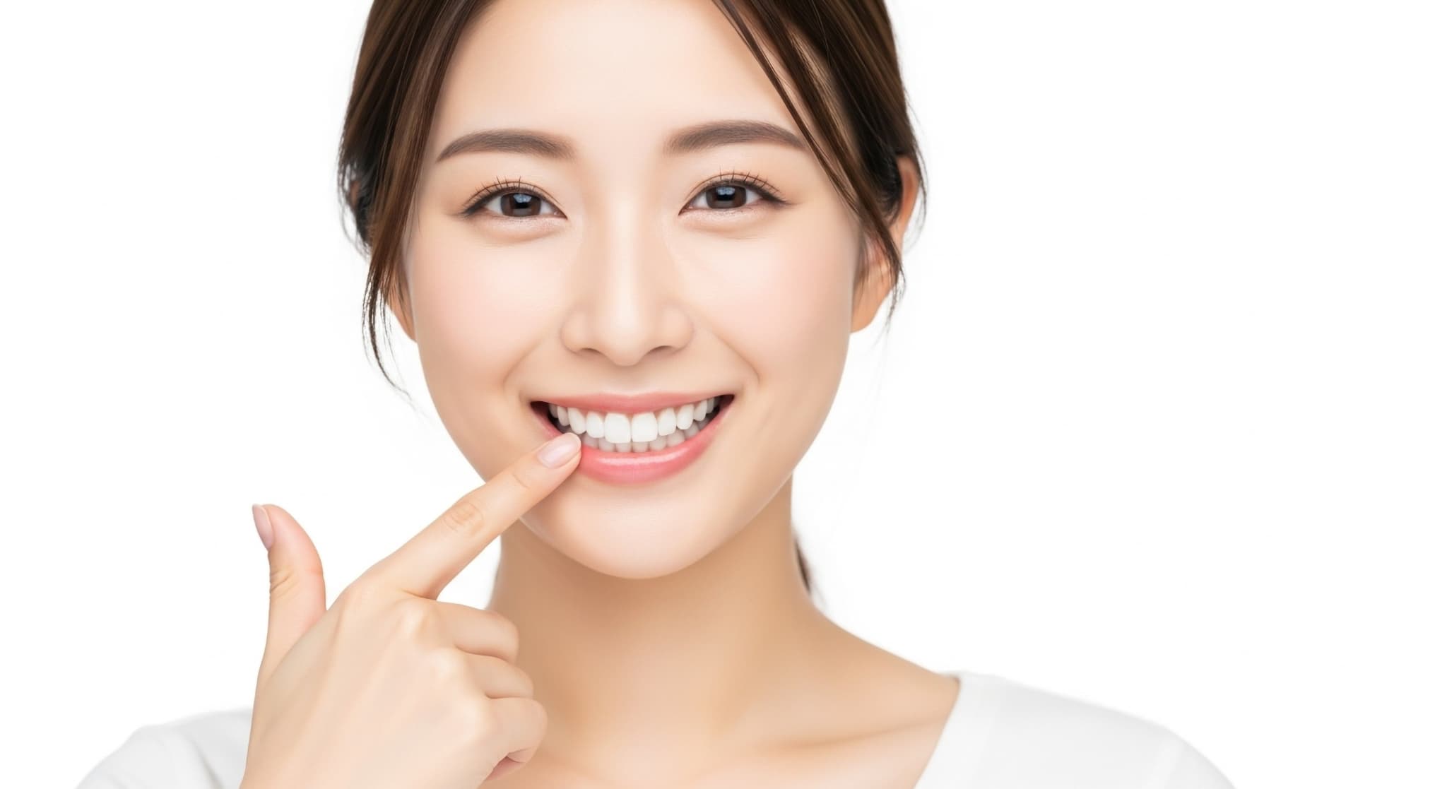 治療した前歯を指さす女性