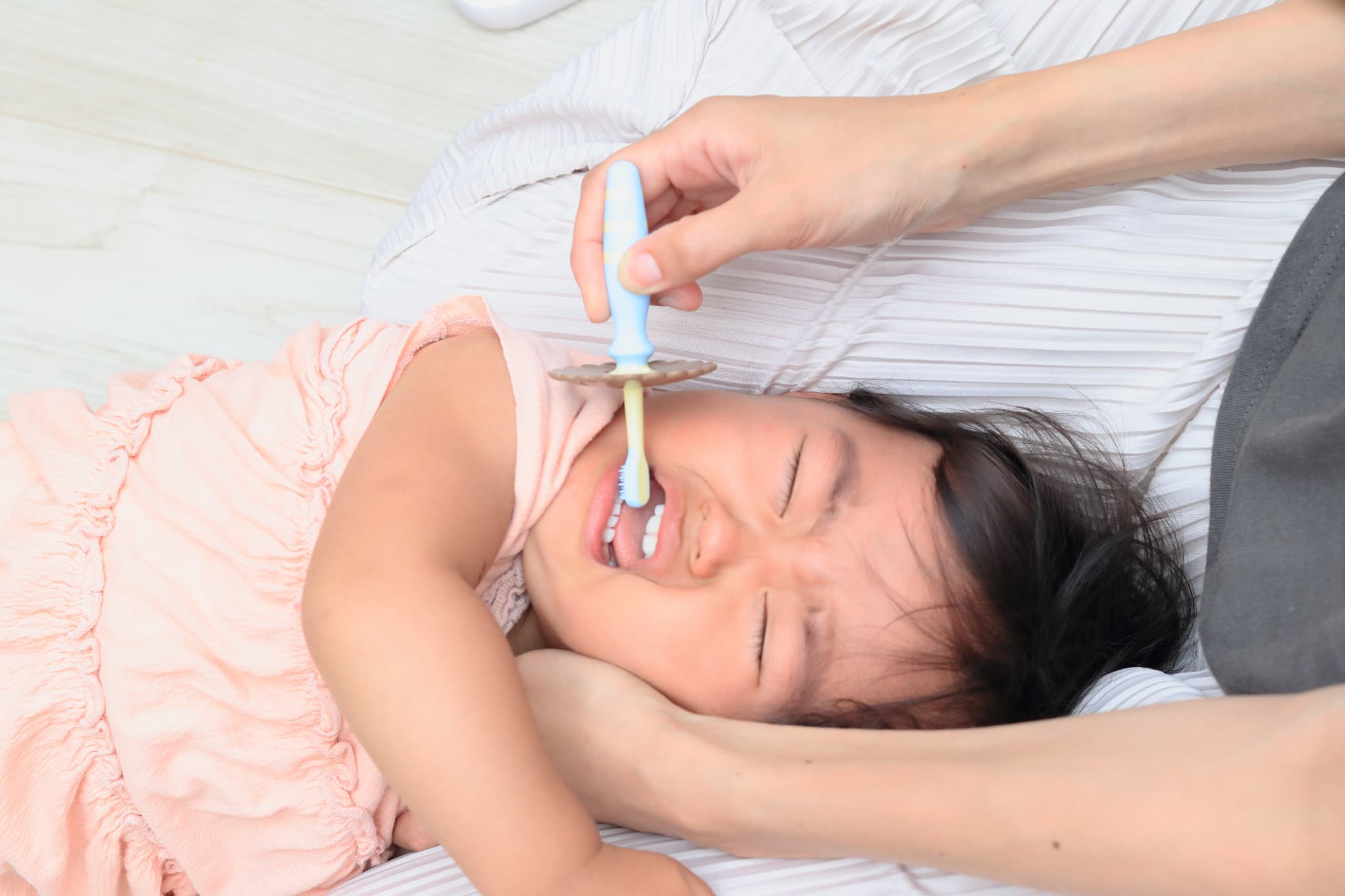 歯磨きを嫌がって泣いている子ども