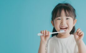 笑顔で歯ブラシを持っている子ども