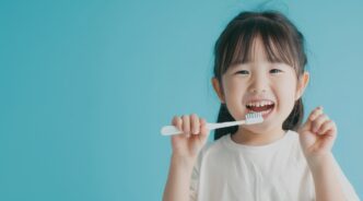 笑顔で歯ブラシを持っている子ども