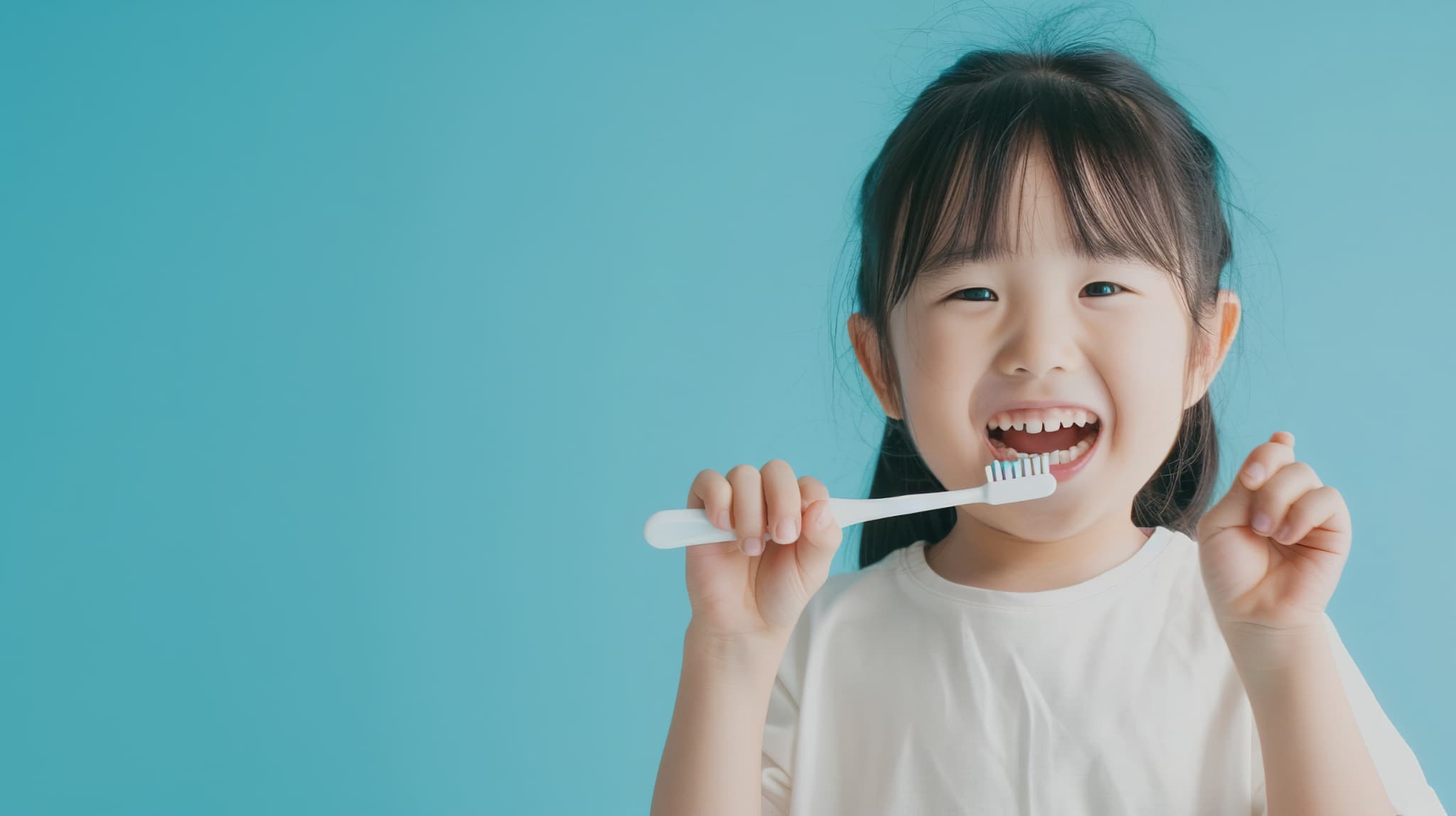 笑顔で歯ブラシを持っている子ども