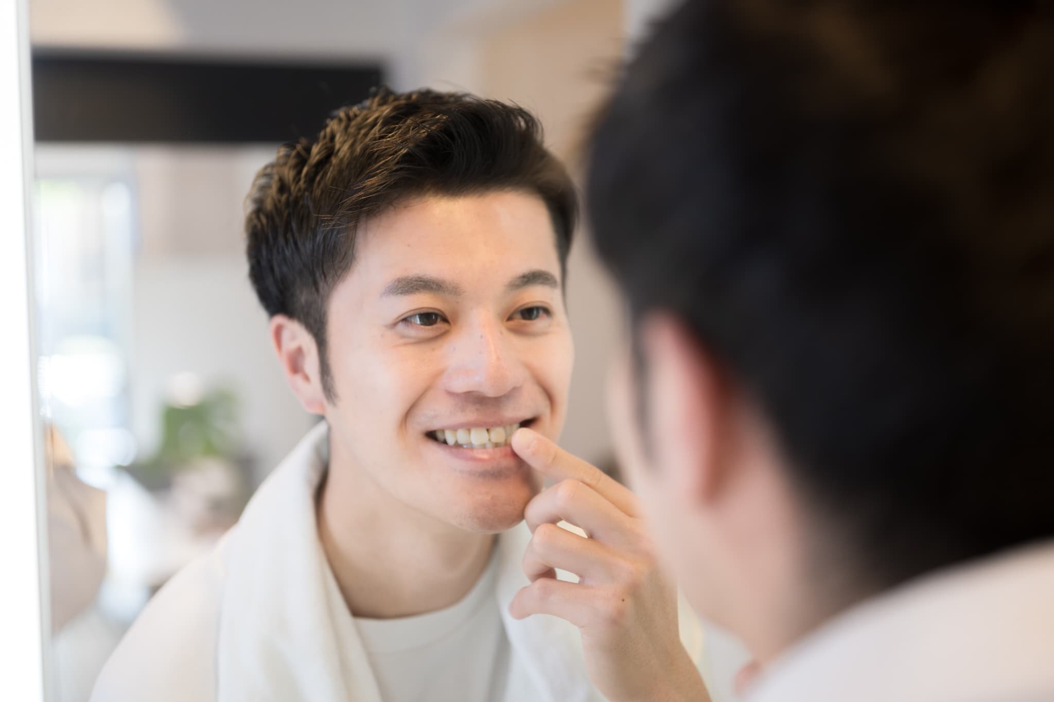鏡で歯の健康を確認する男性